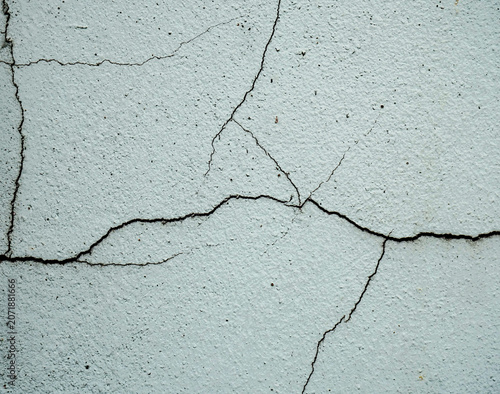 фотографія A detailed close-up shot of cracks on a textured white wall