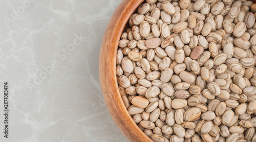 Background image of Brazilian beans called carioca beans in a wooden bowl occupying half the screen.