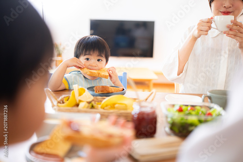朝食にトーストを食べる2歳の男の子