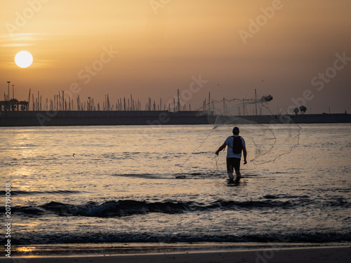 Fishermen on Pinedo beach (Valencia, Spain) at dawn