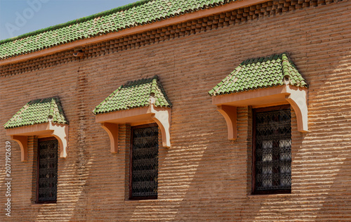 Traditional Moroccan Windows on Brick Wall with Green Tile Roof in Marrakech Medina