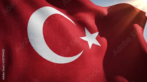 Waving Turkish flag against a bright sunny sky with sun flares