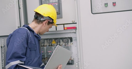 Fotografía A skilled electrical engineer performs system diagnostics, inspecting and operating a high-voltage industrial control panel for quality control and maintenance