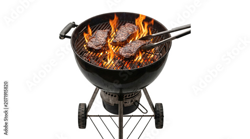 Fotografie Round kettle grill with burning charcoal and three juicy beef steaks being flipped with cooking tongs