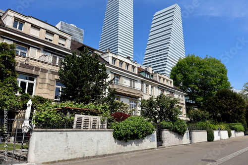 Roche-Türme hinter Häusern am Rheinufer von Basel 