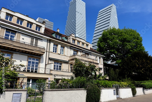 Roche-Türme hinter Häusern am Rheinufer von Basel 