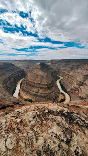 Goosenecks State Park reserve, Utah, USA. The San Juan River needed millions of geological years to carve deep canyons. Dramatic horseshoe-shaped meanders with a blue cloudy sky. UNESCO heritage site.