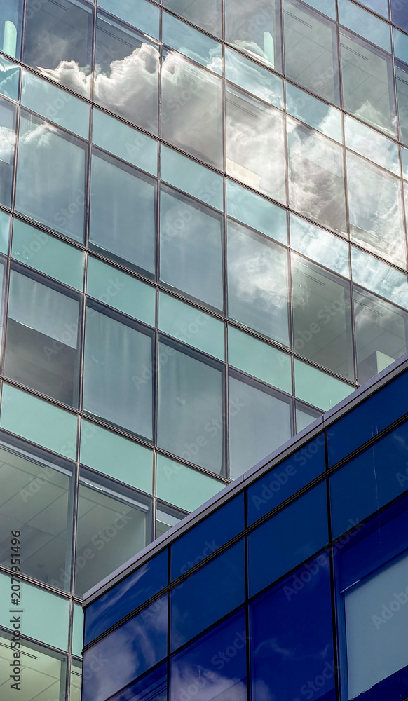 Obraz premium Reflection of clouds in glass building in a city environment