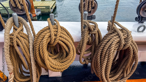 Rope coils hang on a ship's railing near water