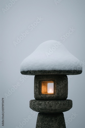 Warm flame flickers inside a frosted stone lantern in winter