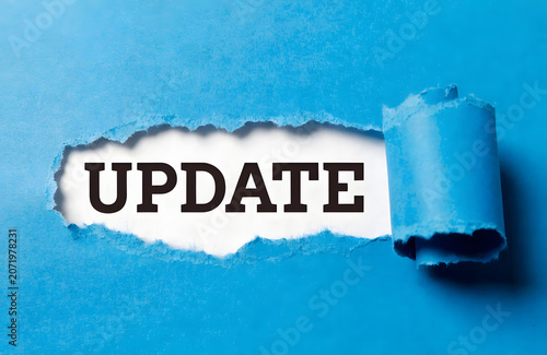 Paper Tear Reveal Showing Update Message On Blue Background For Business News Announcement And Information Concept