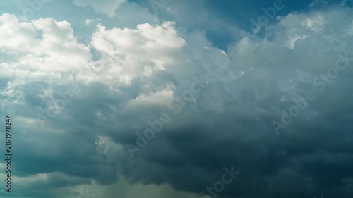 Gloomy storm clouds are gathering in the blue sky. A celestial timelapse of a cloudy sky. The beauty of the sky and nature.