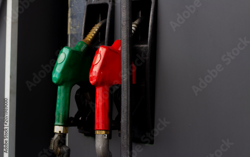 Horizontal street city photo close up. Old black gas station with red and green petrol gun, fuel dispenser, petroleum dispensing nozzle. Concept of sanction, transport, rising oil prices, auto service