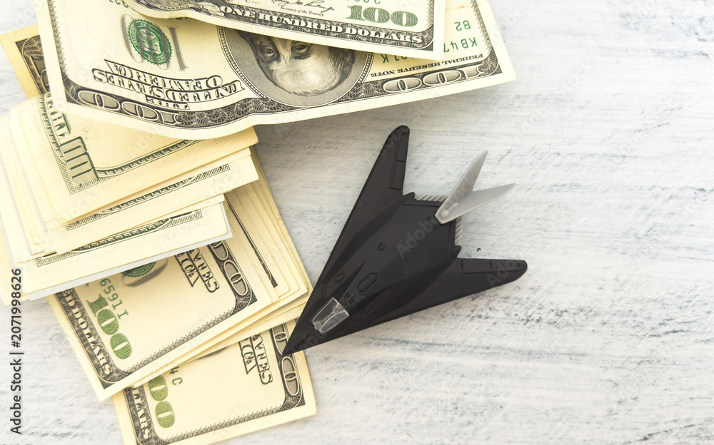 Fototapeta premium military miniature toy airplane on dollars background