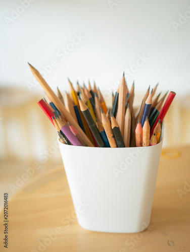 Colorful Pencils in White Cup on Wooden Desk Artist Studio Workspace View