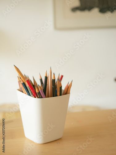 Colorful Pencils in White Cup on Wooden Desk Artist Studio Workspace View