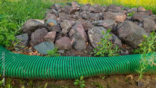 compost filter sock for erosion control and sediment filtration with rock berm landscape drainage solution