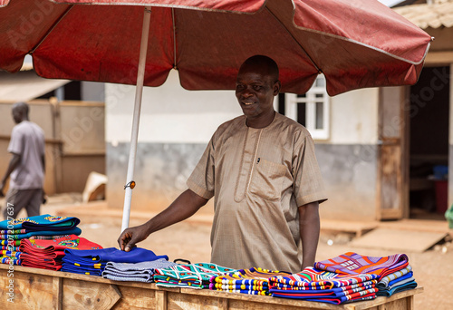 African Merchant Selling Colorful Fabrics and Crafts in Accra Market