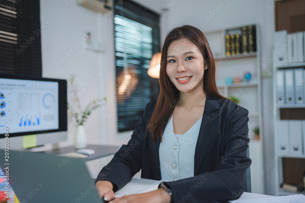 Fototapeta premium Asian businesswoman smiling and working in office