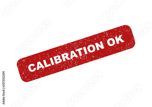 Red rubber stamp impression with the text calibration ok on paper