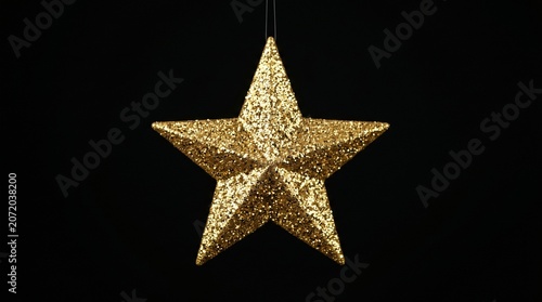 golden star christmas ornament on black background festive holiday decoration sparkling winter symbol