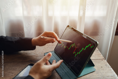 Stock traders are using laptops and smartphones to trade stocks, even in restaurants, in a way that evokes a sense of investment and stock trading.