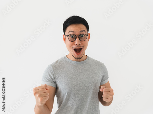 Confident male smiling broadly with fists lifted in achievement