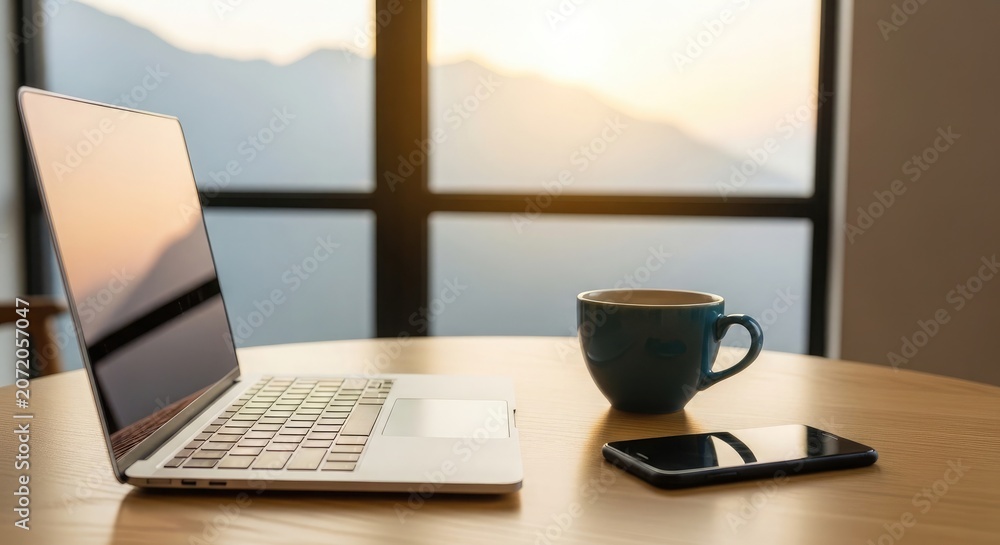 Fototapeta premium Morning coffee and work laptop smartphone and hot beverage on wooden table with scenic view