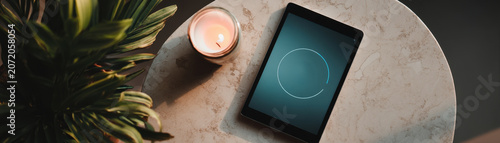 Calm tablet breathing timer digital tablet table meditation app display candle light relaxation cozy evening mood marble table surface indoor home scene mindful technology use wellness routine