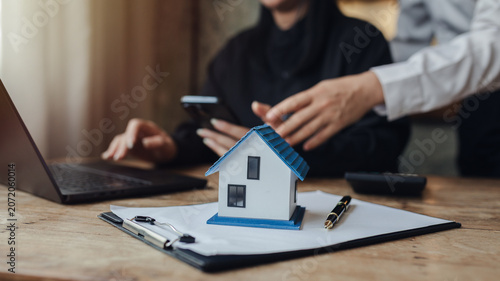 Businessman, house and condo sales representative Hand over the keys to the customer and sign the sales or rental contract according to mutual agreement in the office. Real estate business concept