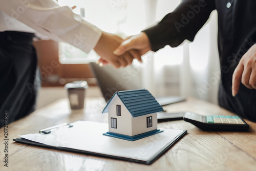 Businessman, house and condo sales representative Hand over the keys to the customer and sign the sales or rental contract according to mutual agreement in the office. Real estate business concept