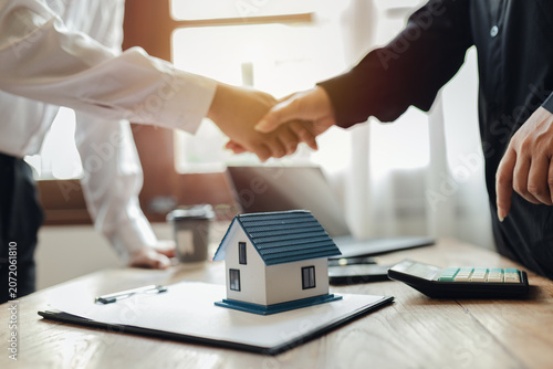 Businessman, house and condo sales representative Hand over the keys to the customer and sign the sales or rental contract according to mutual agreement in the office. Real estate business concept