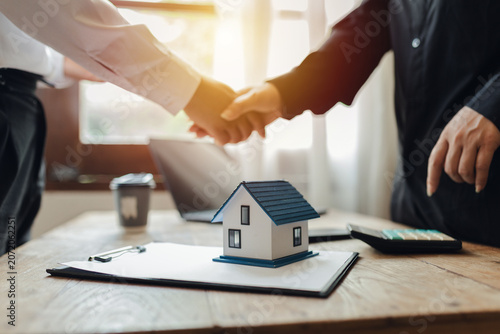 Businessman, house and condo sales representative Hand over the keys to the customer and sign the sales or rental contract according to mutual agreement in the office. Real estate business concept