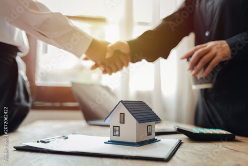Businessman, house and condo sales representative Hand over the keys to the customer and sign the sales or rental contract according to mutual agreement in the office. Real estate business concept