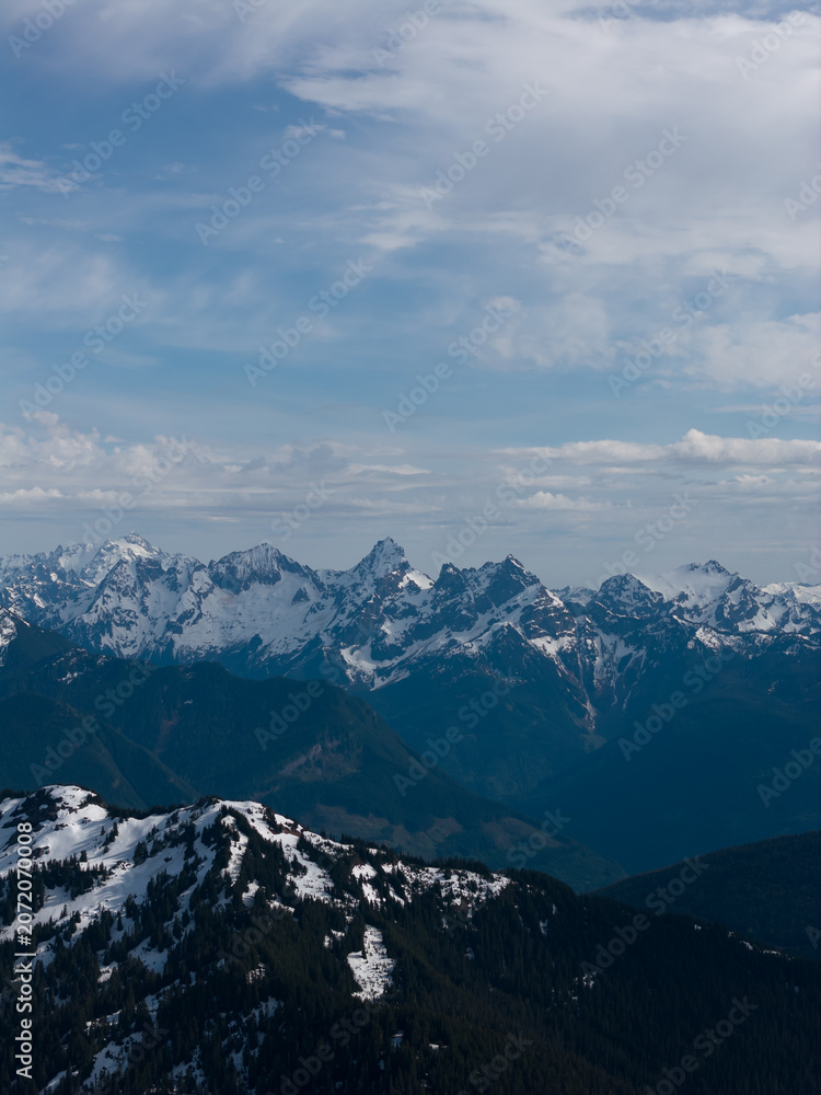 Obraz premium Snow-Covered Mountain Peaks Under Blue Sky in British Columbia, Canada Alpine Landscape
