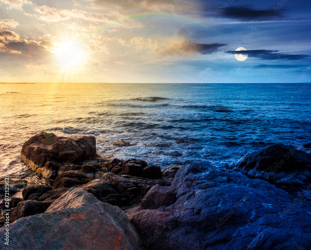 Naklejka premium sea coast with stones and rocks. day meet night. summer vacation background at twilight. sun and moon in harmony over seascape with rough terrain. relaxing at the sea. coast of bulgaria wallpaper