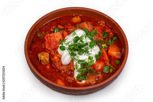Photography Red borscht seasoned with sour cream and potherbs in bowl