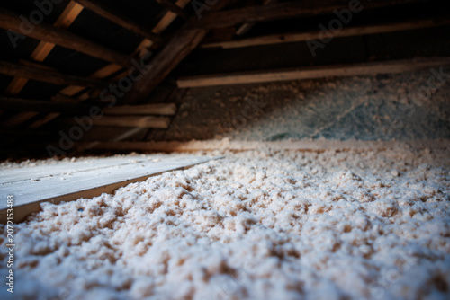 Canvastavla Inside an older wooden house in Riga, a low angle view shows thick cellulose insulation on the attic floor, exposed beams, a narrow plank path, and warm, low lighting