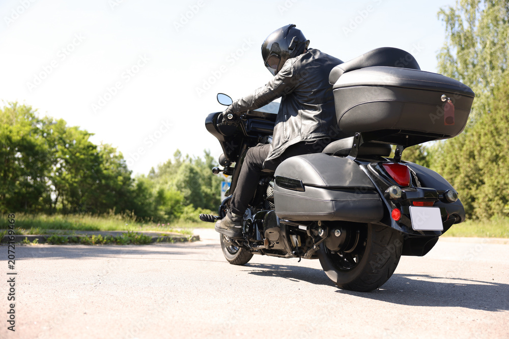 Fototapeta premium Man driving modern motorcycle outdoors, space for text