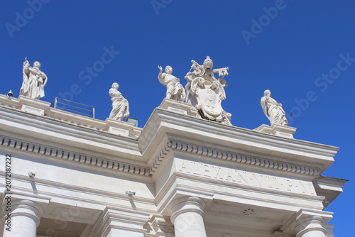 VATICAN CITY - JUNE 6, 2016: Statues and Pope Alexander VII coat of arms on St. Peter's Square colonnade