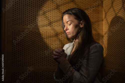Foto Woman at Catholic Church confession booth talking with priest.
