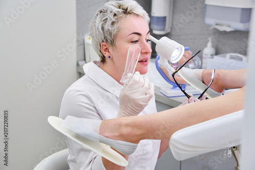 Фотография Gynecologist with vaginal speculum in clinic before patient examination