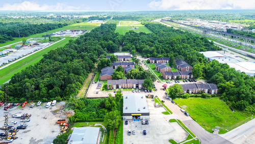 Aerial view of apartment complex and industrial area with surrounding greenery