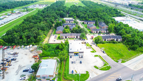 Aerial view of a commercial and residential area with parking lots and trees