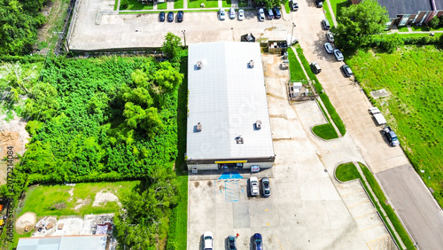 Aerial view of a commercial warehouse building with a parking lot in a suburban area