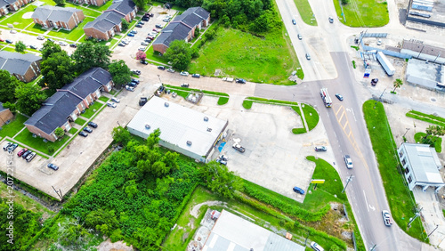 Aerial view of a commercial building and residential apartment complex in a suburban area