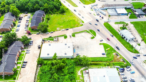 Aerial view of a commercial building with a large parking lot in a suburban area