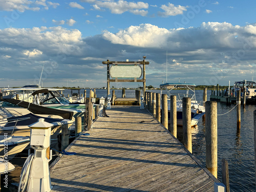Wooden Dock With Boats by the Water Under Clouds During Sunset