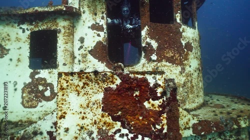 Scuba Diver Exploring Inside the Doorway of a Sunken Tugboat Shipwreck