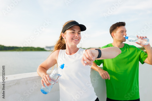 Obraz na plátne Wellness seekers unwind by the waterfront after an invigorating workout on a sun
